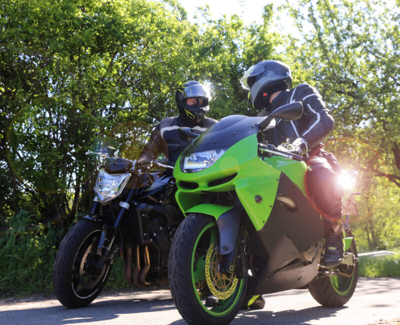 Zwei Motorradfahrer bei einem kurzen Zwischenstopp Zwei Motorradfahrer bei einem kurzen Zwischenstopp